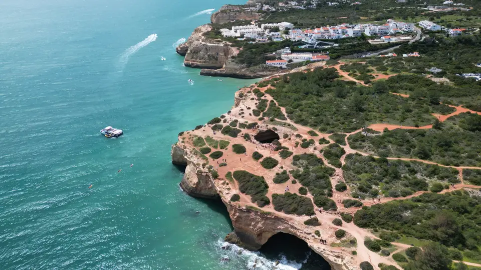 Stunning aerial view of the Algarve coastline with dramatic cliffs and turquoise waters in Portugal.