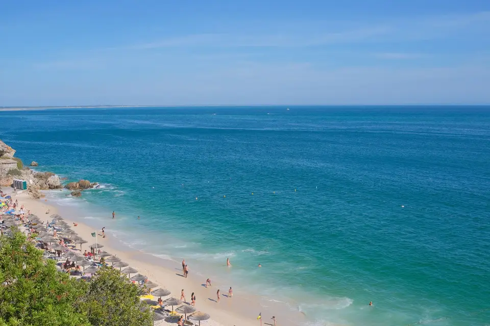 Experience the serene beauty of Portinho da Arrábida's beach with its clear waters and vibrant summer atmosphere.