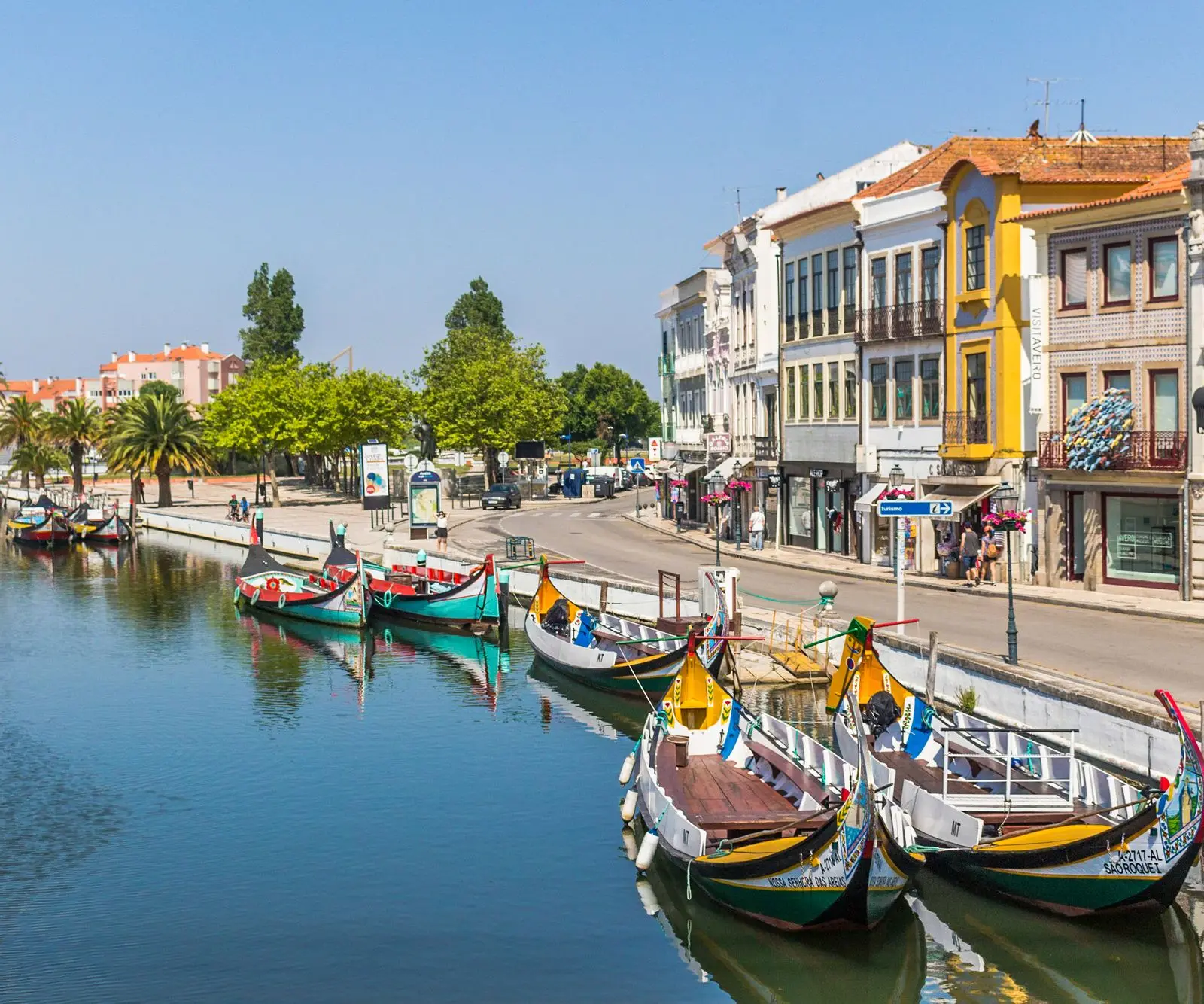 Colorful gondolas along the picturesque canal in Aveiro, Portugal, under a bright sky.