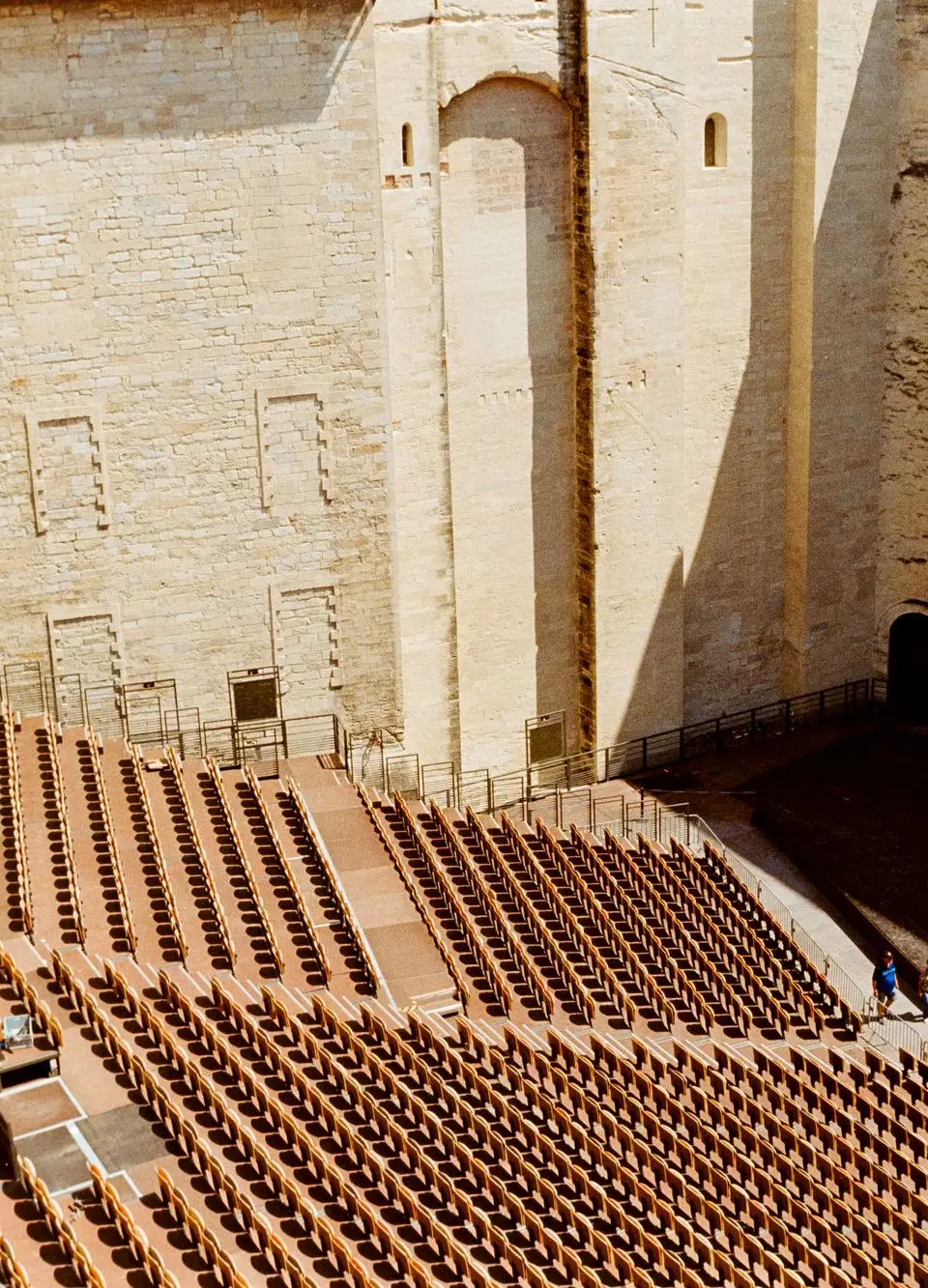 Outdoor view of an empty amphitheater seating area inside the historic Palais des Papes in Avignon, France.