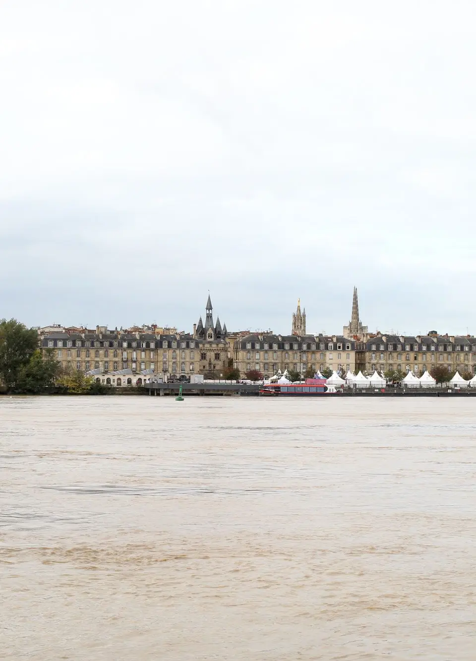 A scenic view of Bordeaux, France with historical architecture along the riverbank.