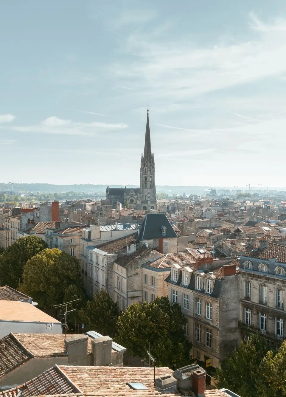 Aerial view of Bordeaux, France, featuring architectural rooftops and the iconic church spire.