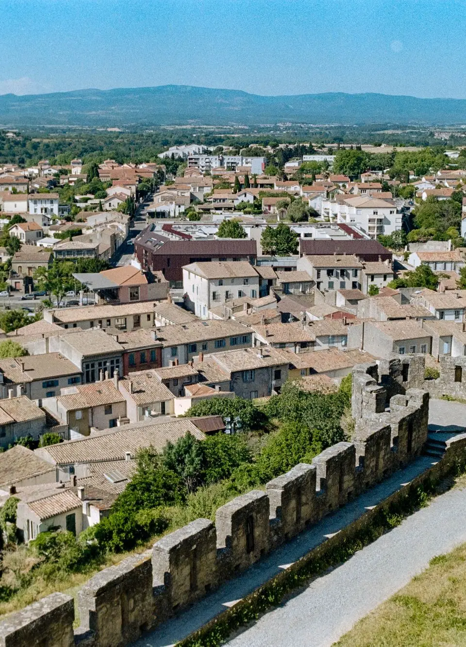 Aerial view of the historic walls and rooftops of Carcassonne, Occitanie, France on a sunny day.