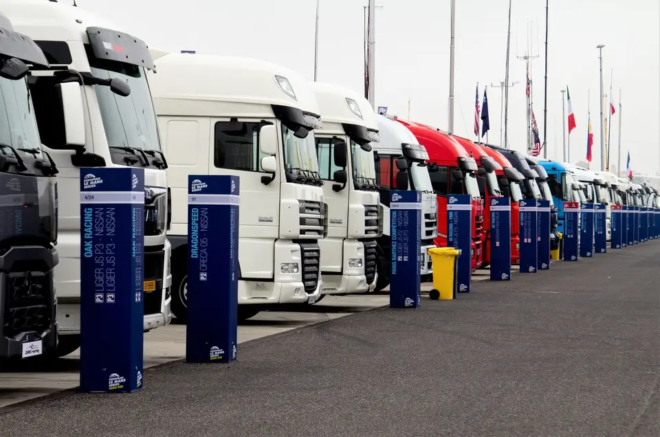 Line of racing trucks with bollards at event in Estoril, Portugal.