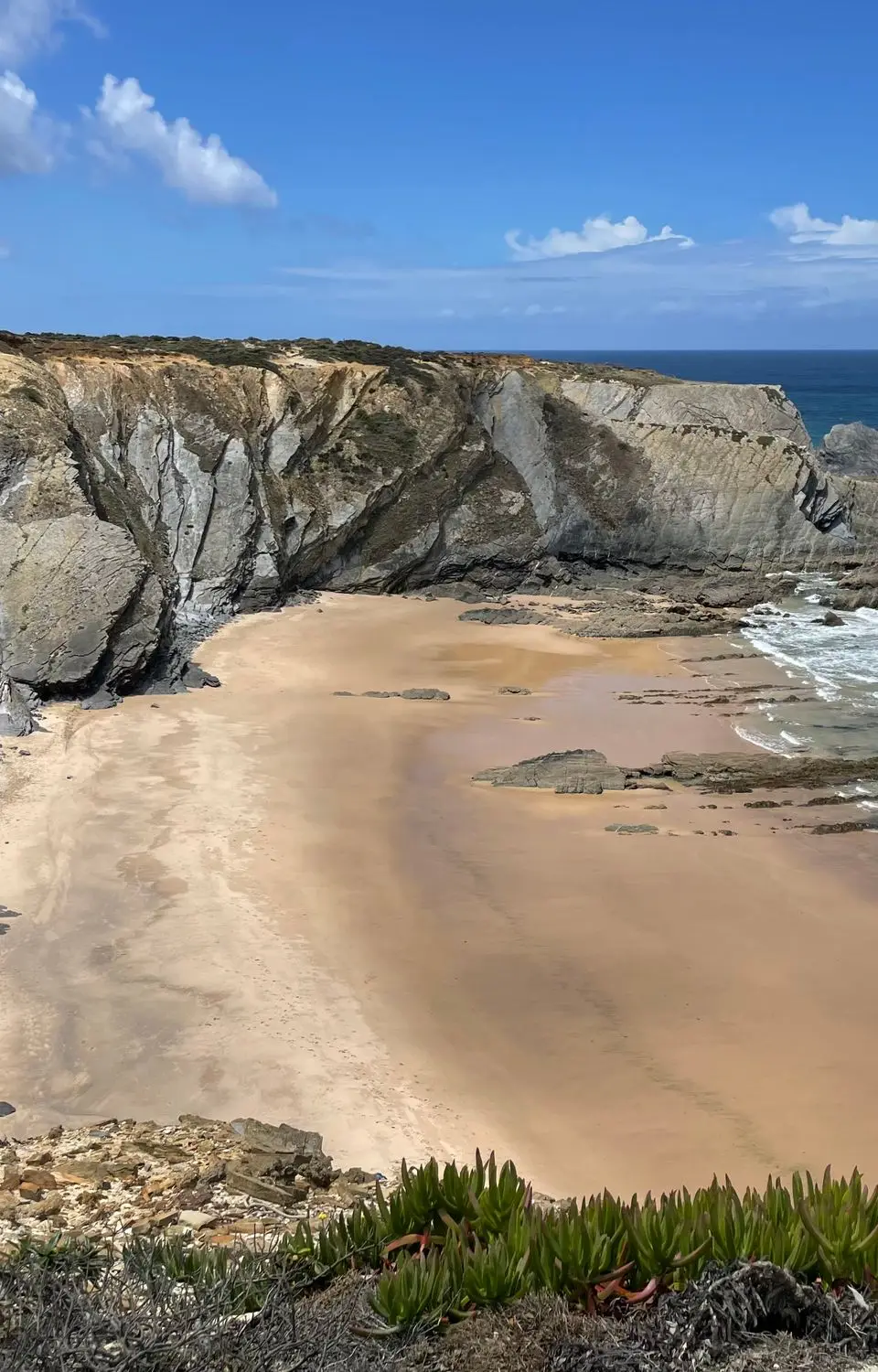 Beautiful view of Carvalhal Beach in Alentejo with cliffs and Atlantic Ocean waves.