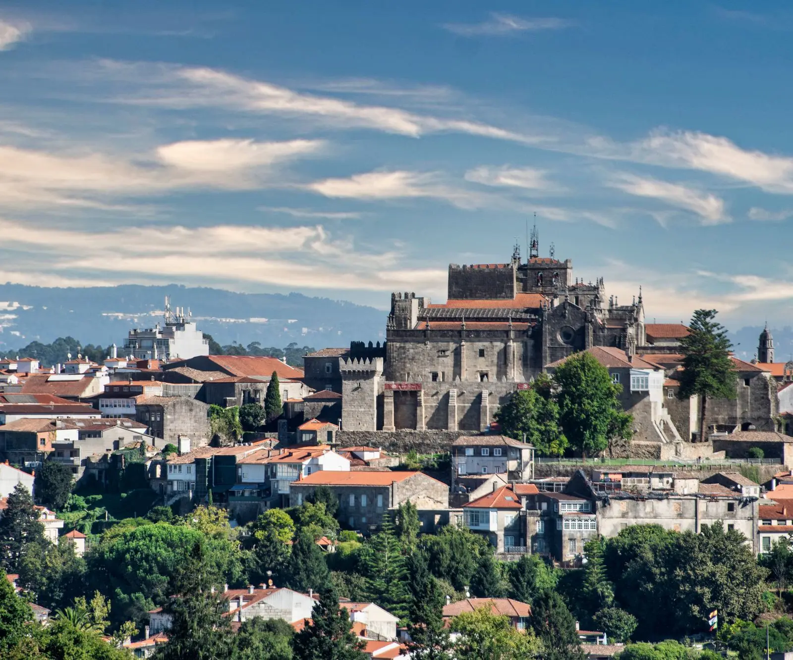 A scenic view of Guimarães with its historic medieval castle under a clear blue sky.