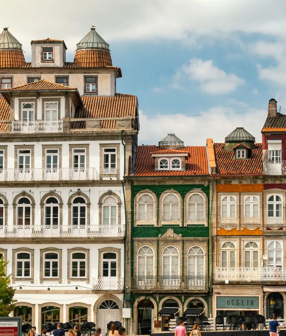 Vibrant historic building facades in Guimarães, Portugal with pedestrians in public space.
