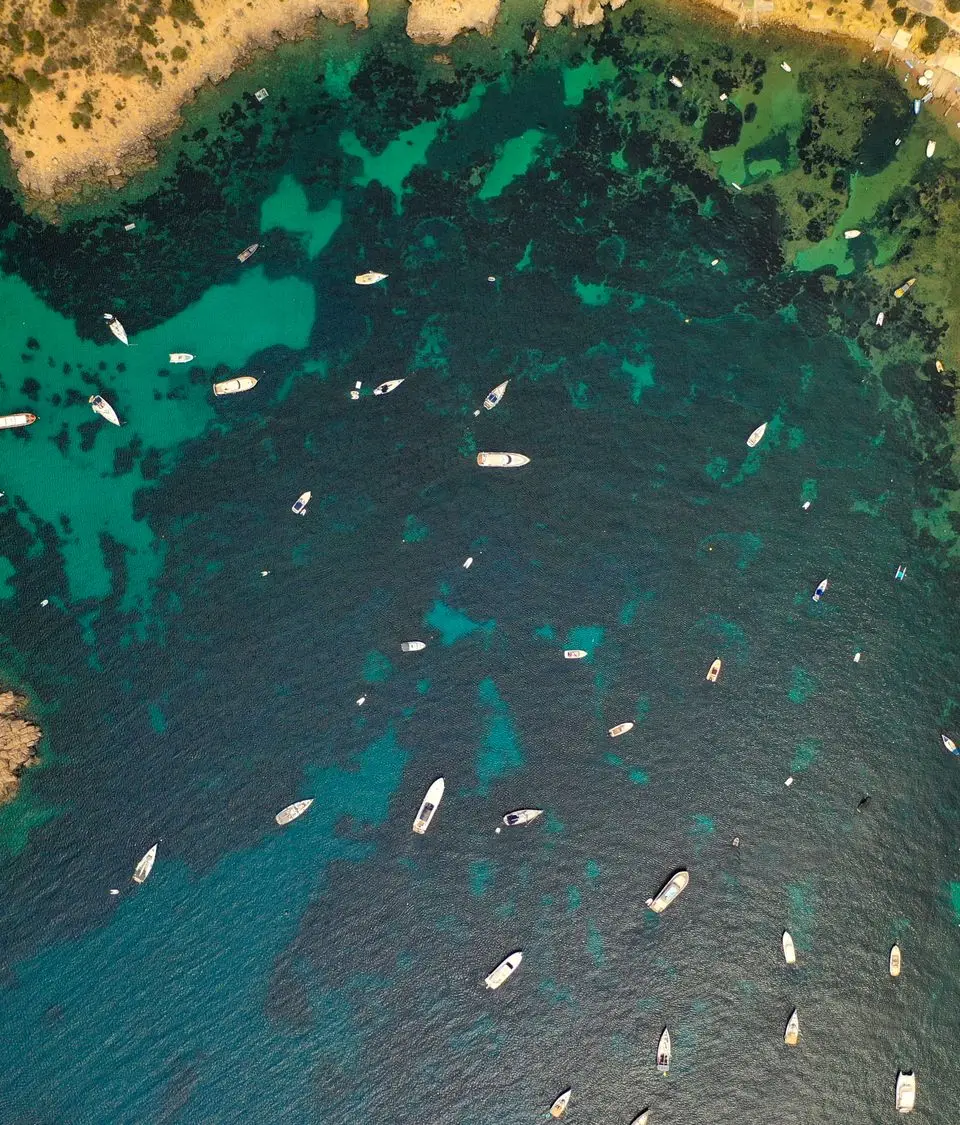 Stunning aerial view of Ibiza's coastline with boats and clear waters.