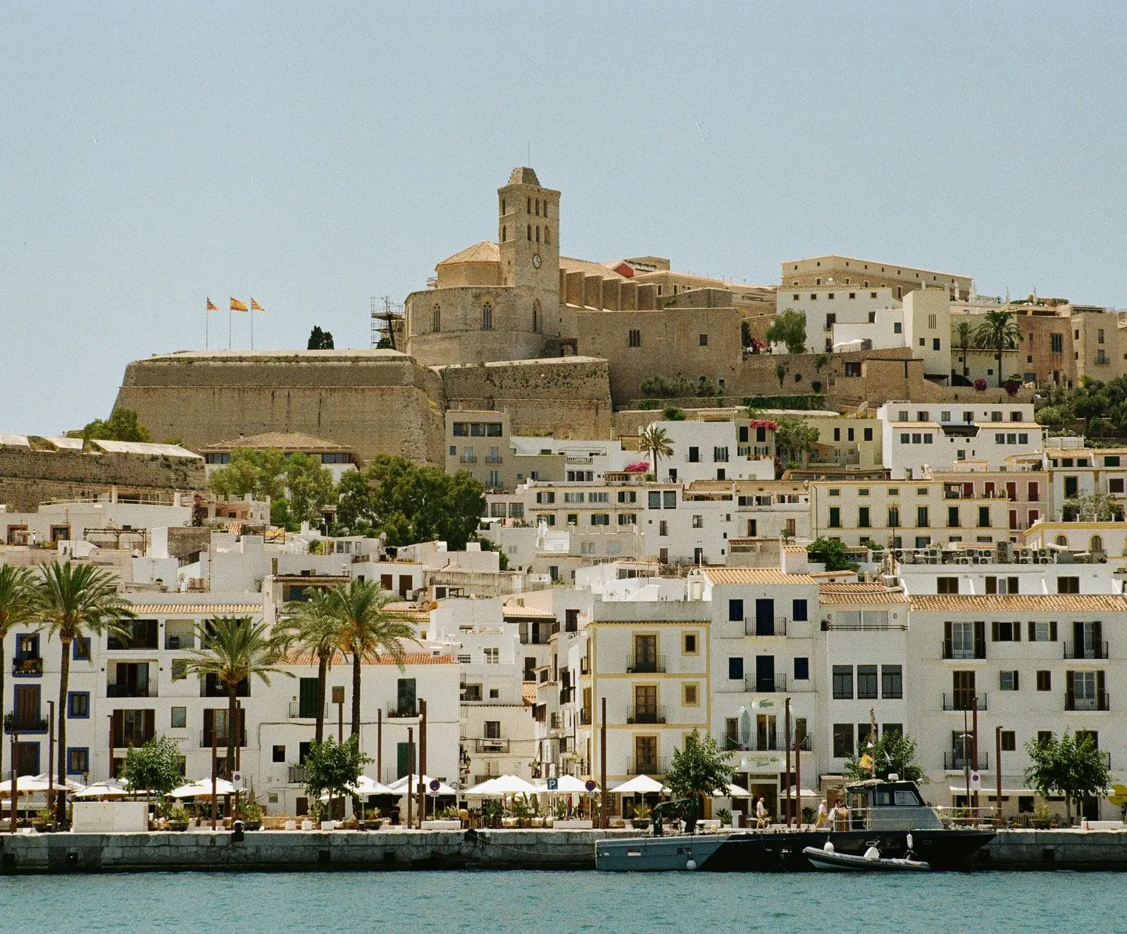 View of historic Dalt Vila in Ibiza Town, Spain, with whitewashed buildings and clear blue sky.