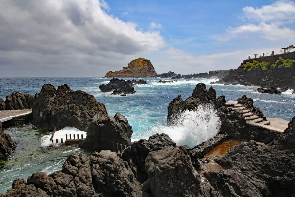 Stunning view of crashing waves at Porto Moniz's rocky natural pools on Madeira Island, Portugal.