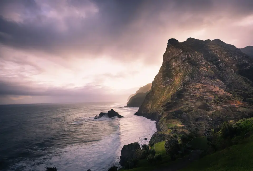 Breathtaking view of Madeira's rugged coastline with cliffs illuminated by the sunset.