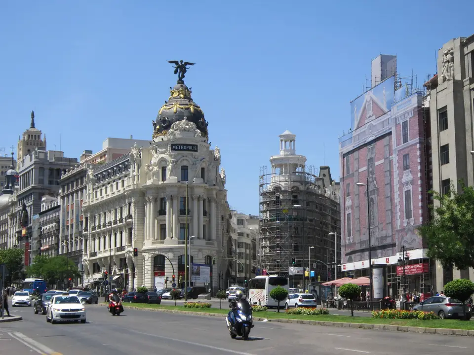 Street view of the Metropolis Building and Gran Vía in Madrid on a sunny day.