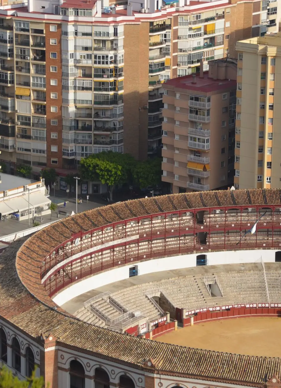 High-angle view of the iconic Plaza de Toros surrounded by urban buildings in Málaga, Spain.
