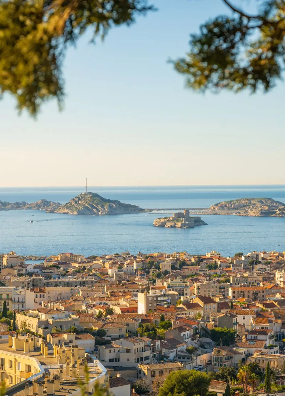 Panoramic view of the city of Marseille with a clear view of the Mediterranean Sea and nearby islands.