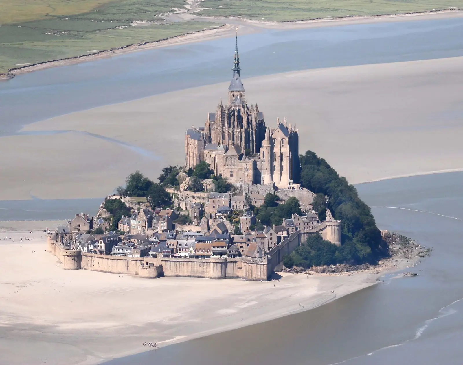 Stunning aerial shot of the iconic Mont Saint-Michel surrounded by tidal waters in Normandy, France.