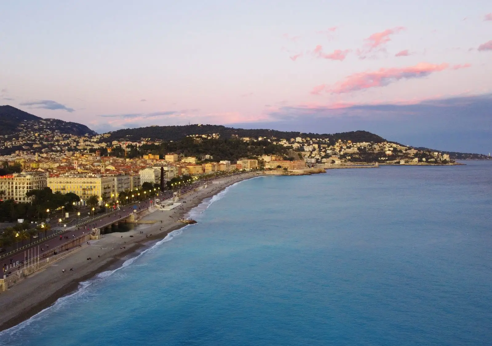 A breathtaking aerial view of Nice, France, with the Promenade des Anglais and Mediterranean Sea at sunset.