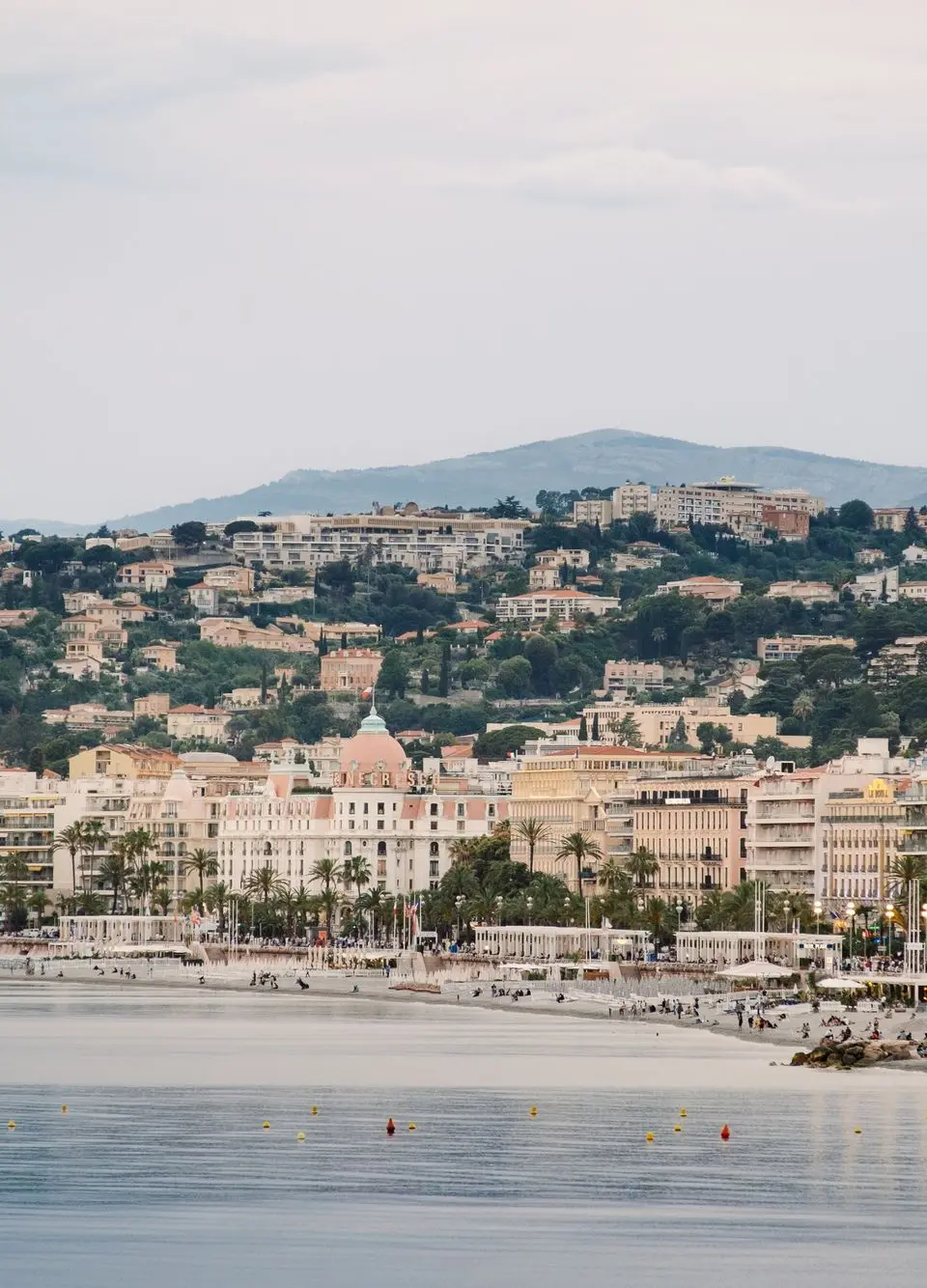 Scenic view of Nice seafront with buildings and mountains, French Riviera.