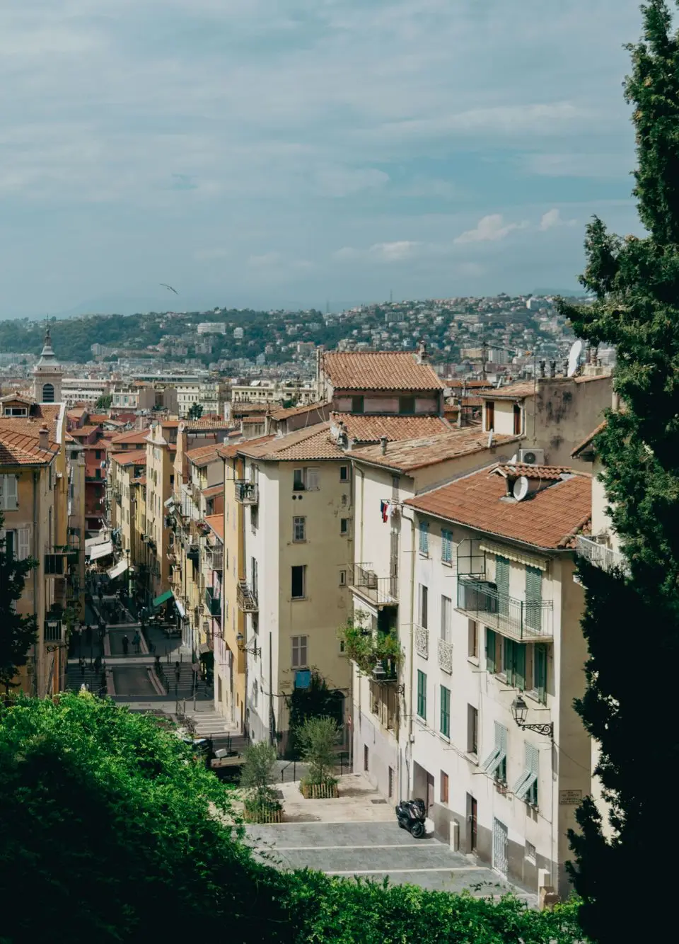 Explore the picturesque streets of Nice with historic architecture and stunning hillside views.