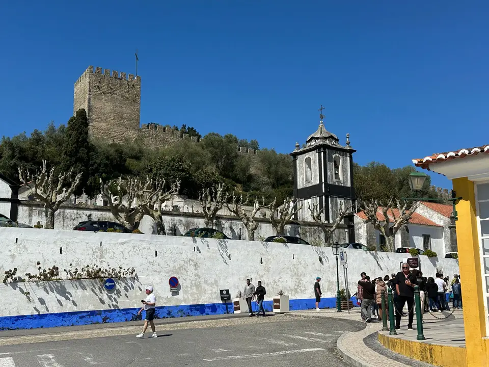 Óbidos Castle and bustling street scene, capturing historical architecture in Portugal.