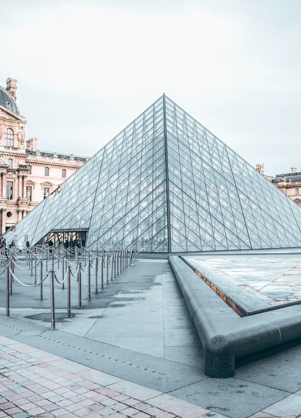 Iconic Louvre Pyramid in Paris, showcasing classic and modern architecture.