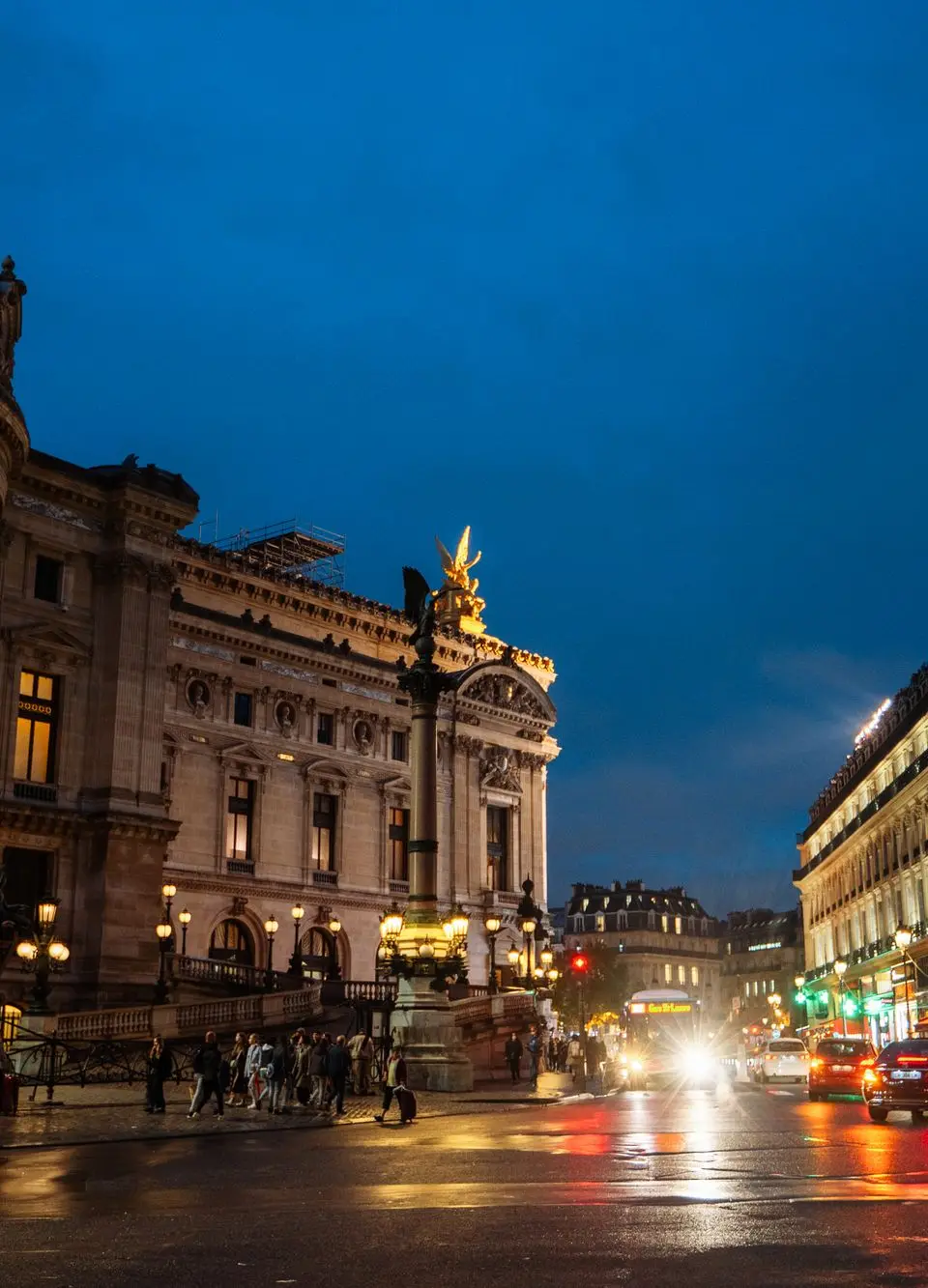 Paris night scene featuring the Opéra Garnier, vibrant city life, and illuminated streets.