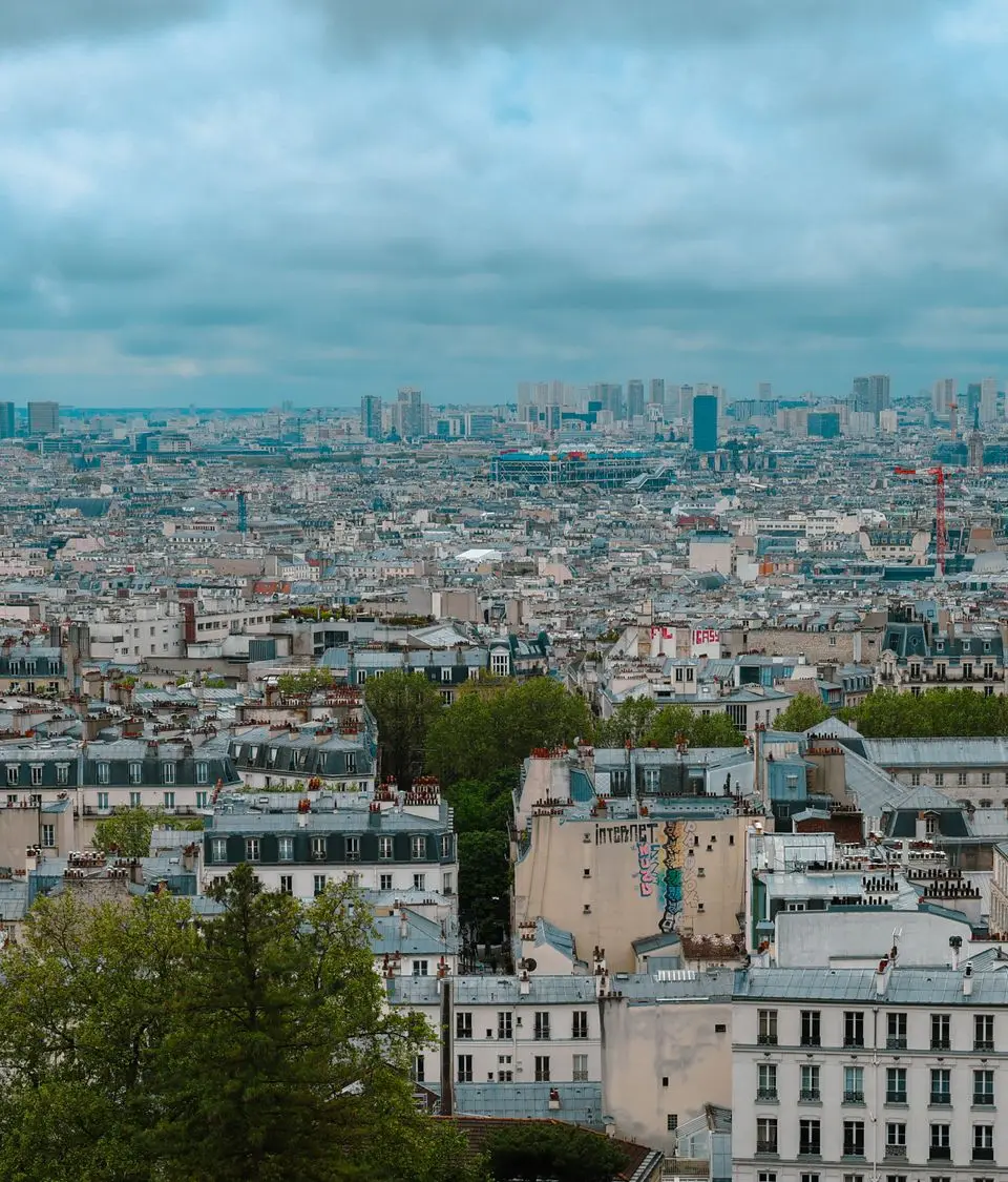 Stunning view of Paris skyline with historic rooftops on a cloudy day, seen from Montmartre.