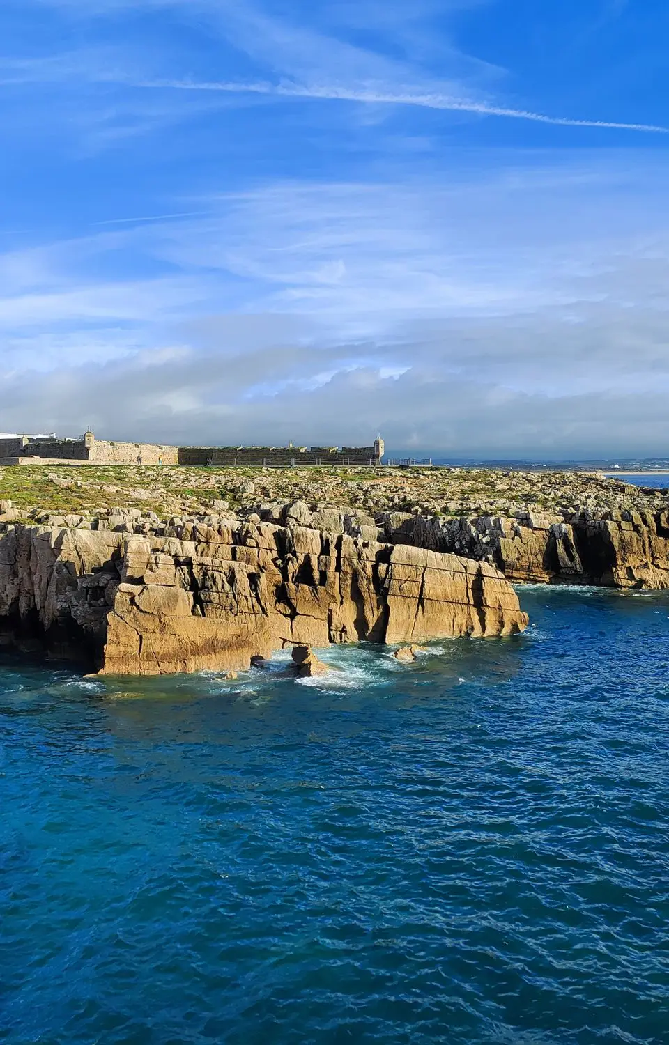 Stunning aerial view of rocky cliffs and blue sea at Peniche, Portugal's rugged coastline.