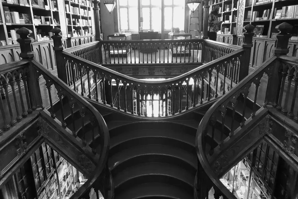 Intricate wooden staircase in a historic Porto library, showcasing timeless architecture.