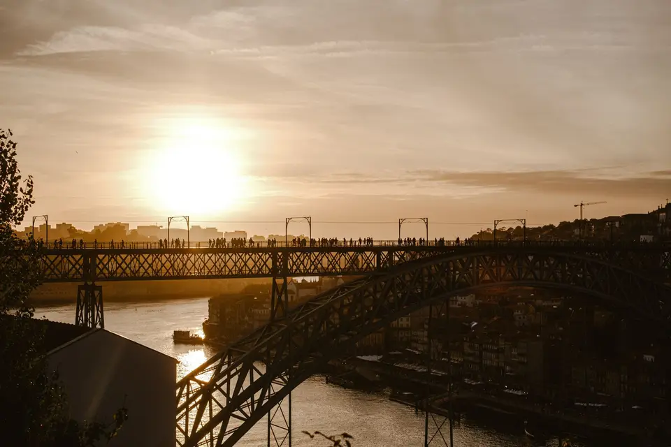 Silhouette of people on the Dom Luís I Bridge at sunset in Porto, Portugal.