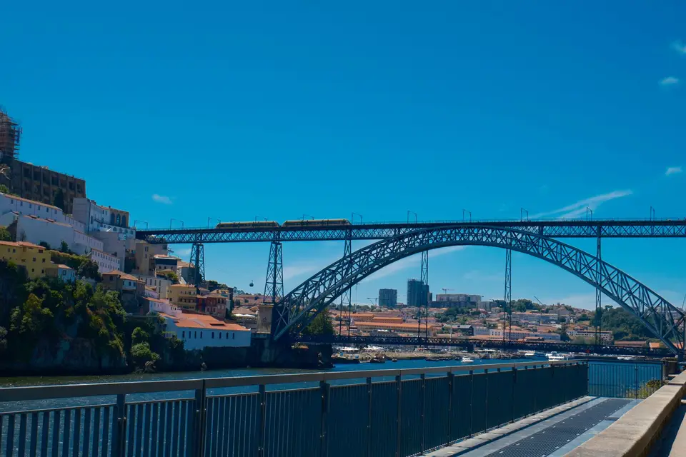 A scenic view of the iconic Dom Luis I Bridge in Porto, Portugal on a sunny day.
