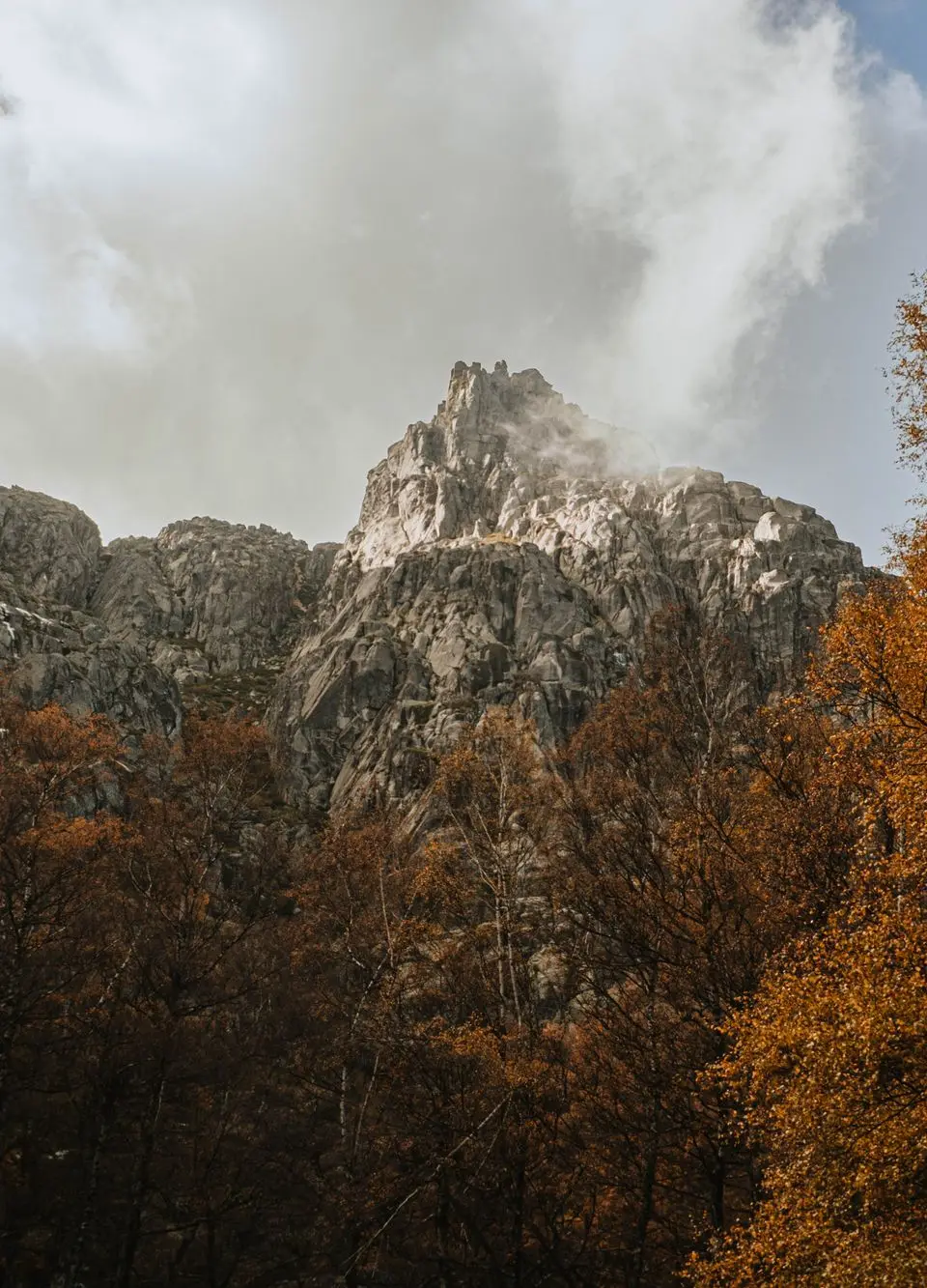 Majestic rocky mountains surrounded by autumn foliage in Manteigas, Portugal.