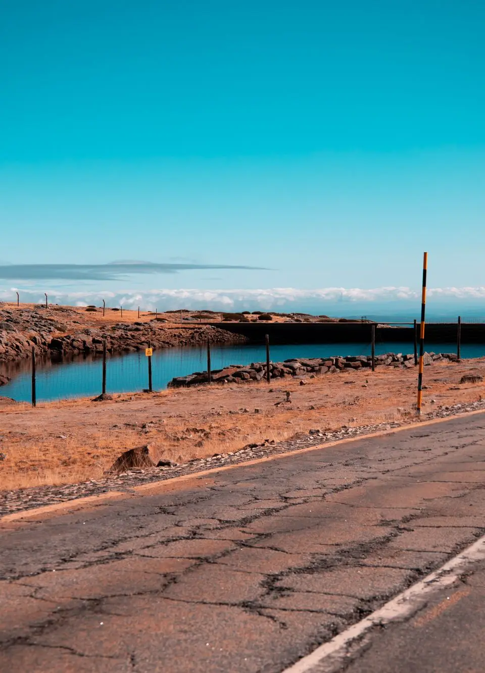 Explore the serene landscape of Covilhã with a stunning view of the roadway and vibrant blue sky.
