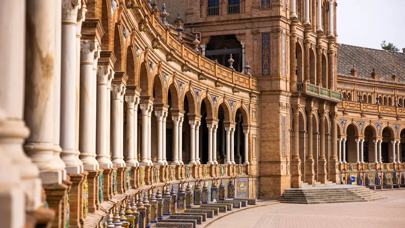 Elegant arches and ornate architecture of Plaza de España in Seville, Spain, showcasing historical grandeur.