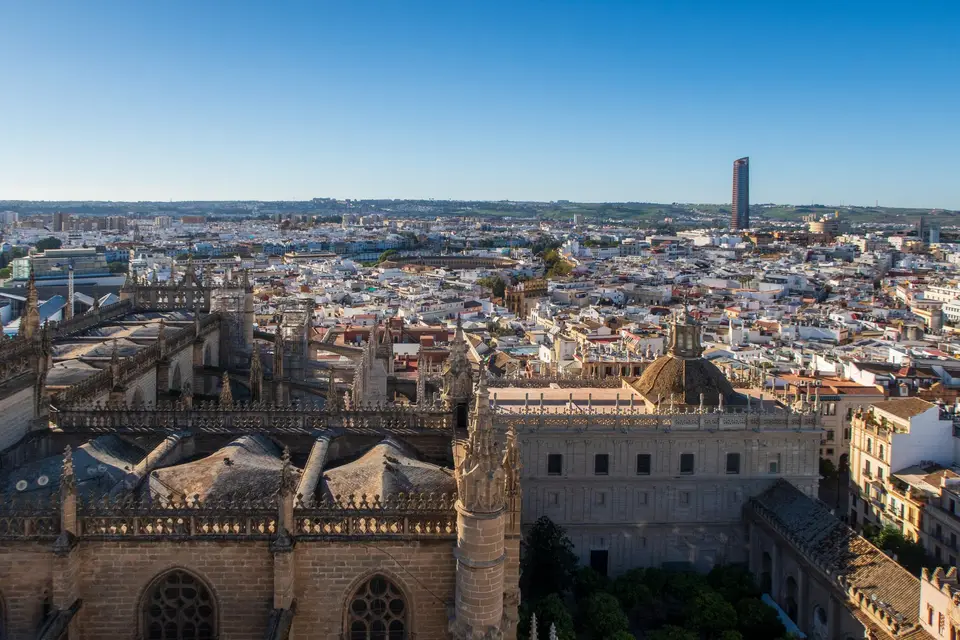 Aerial view of Seville's historic Cathedral and cityscape. Clear day, architectural marvel.