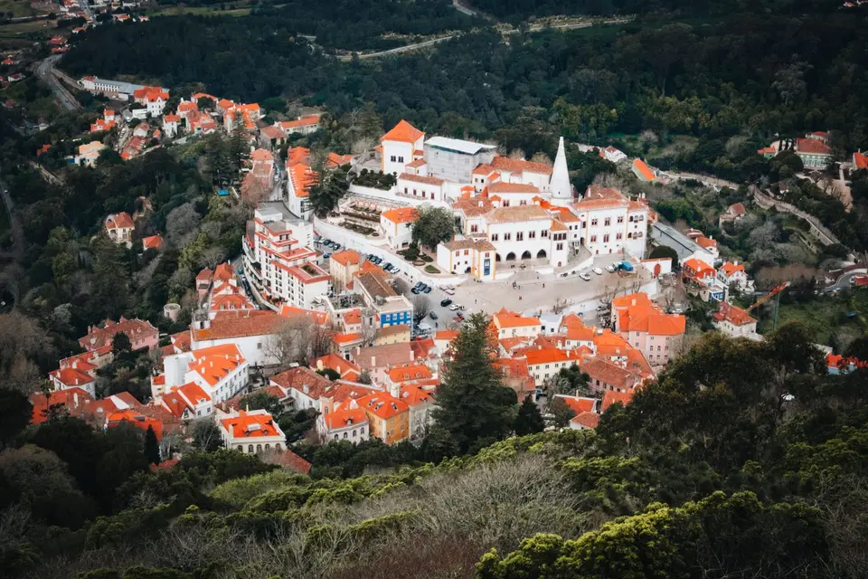 Stunning aerial view of Sintra National Palace, surrounded by lush greenery and historic architecture in Portugal.