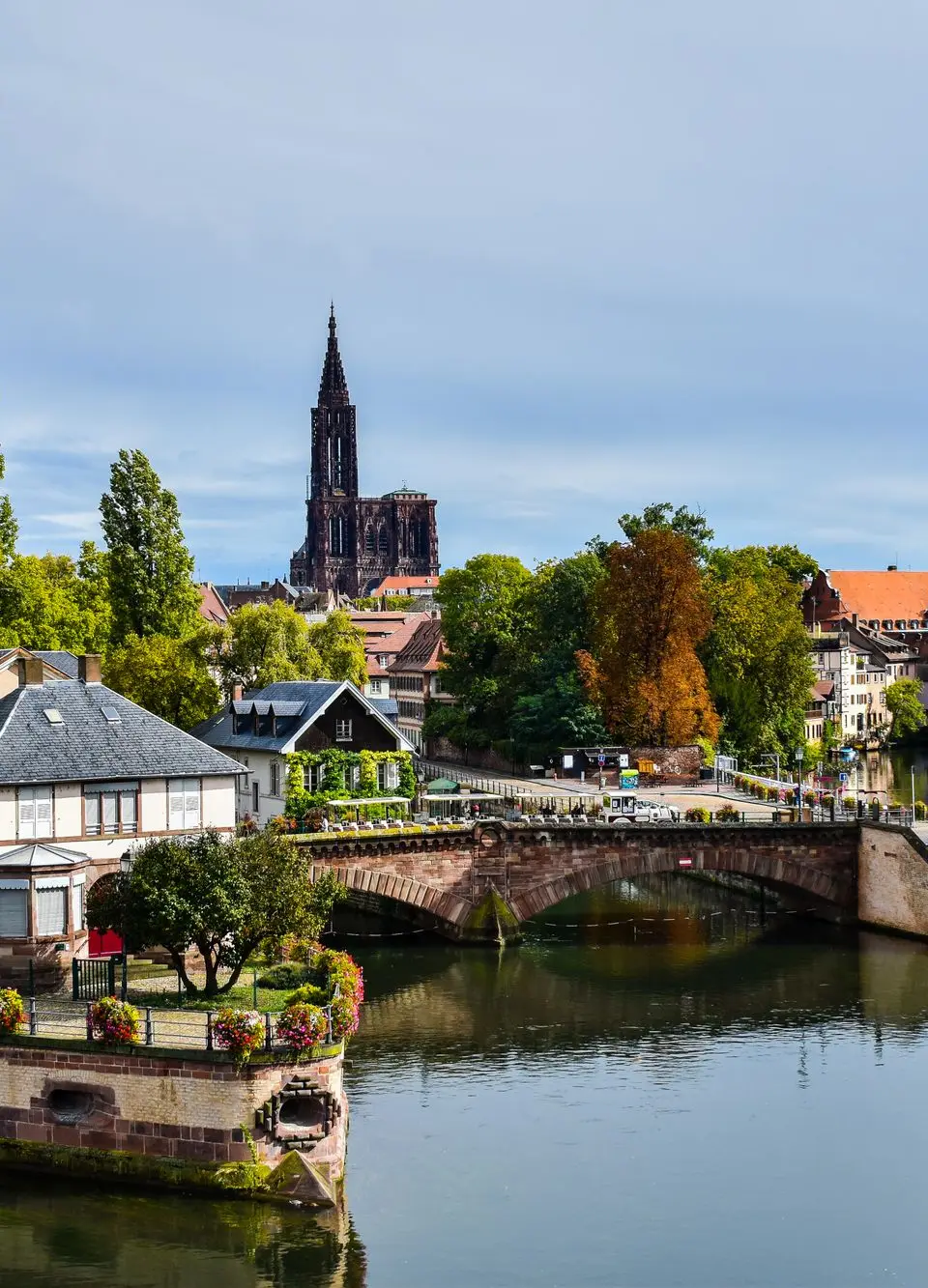 A scenic view of Strasbourg featuring Ponts Couverts and the cathedral in the background.