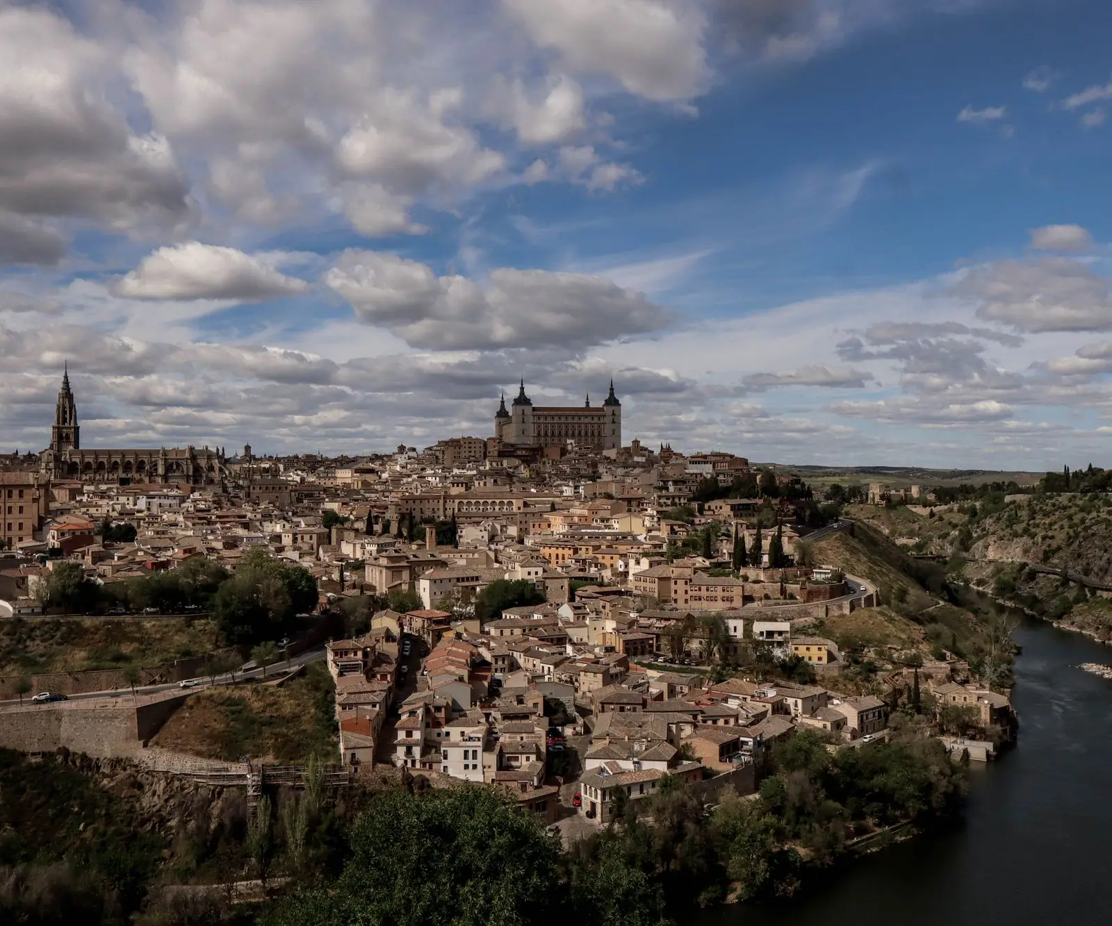 Stunning panoramic view of Toledo, Spain showcasing the Alcázar and historic architecture under a cloudy sky.