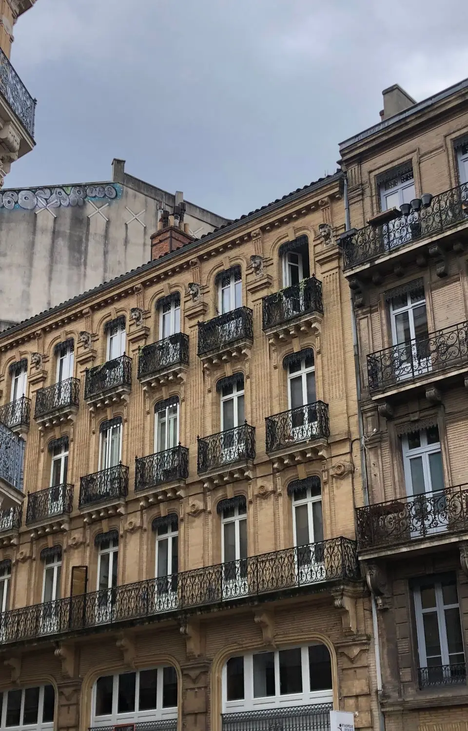 Elegant historic buildings with wrought iron balconies in Toulouse, France.