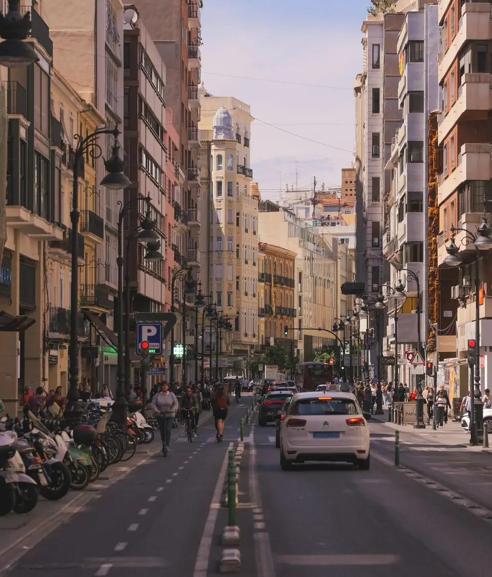 Lively street in Valencia, Spain with classic architecture and vibrant city life.