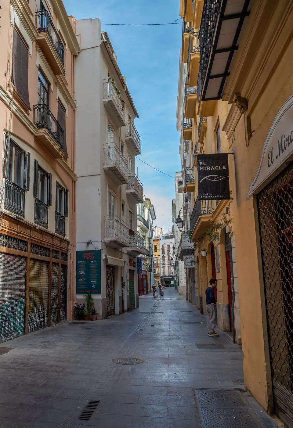 Explore a quaint alleyway in Valencia's historic quarter, revealing its urban charm and vibrant street art.