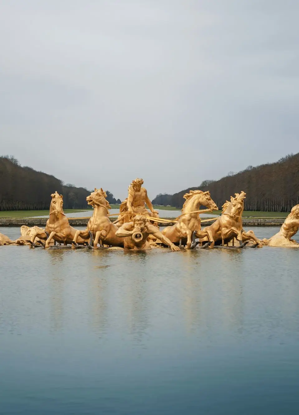 A stunning view of the Apollo Fountain in Versailles, France, reflecting in the water.